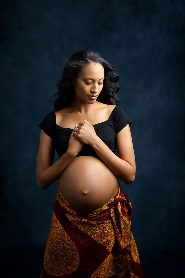 image of maternity mother wearing a black cropped top showing off her baby bump