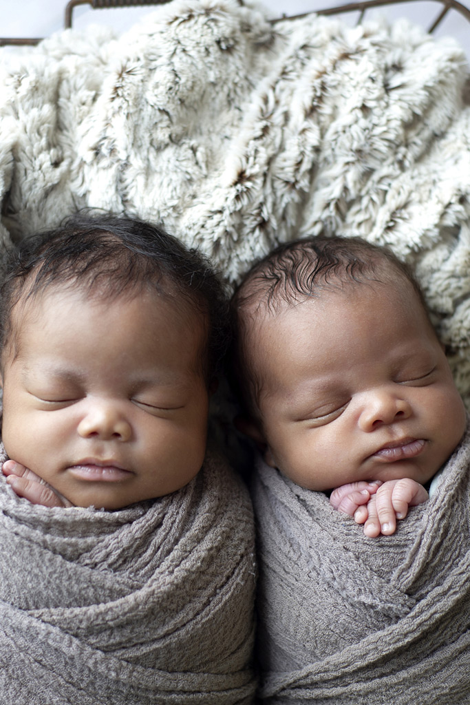 twin newborn boys wrapped in basket