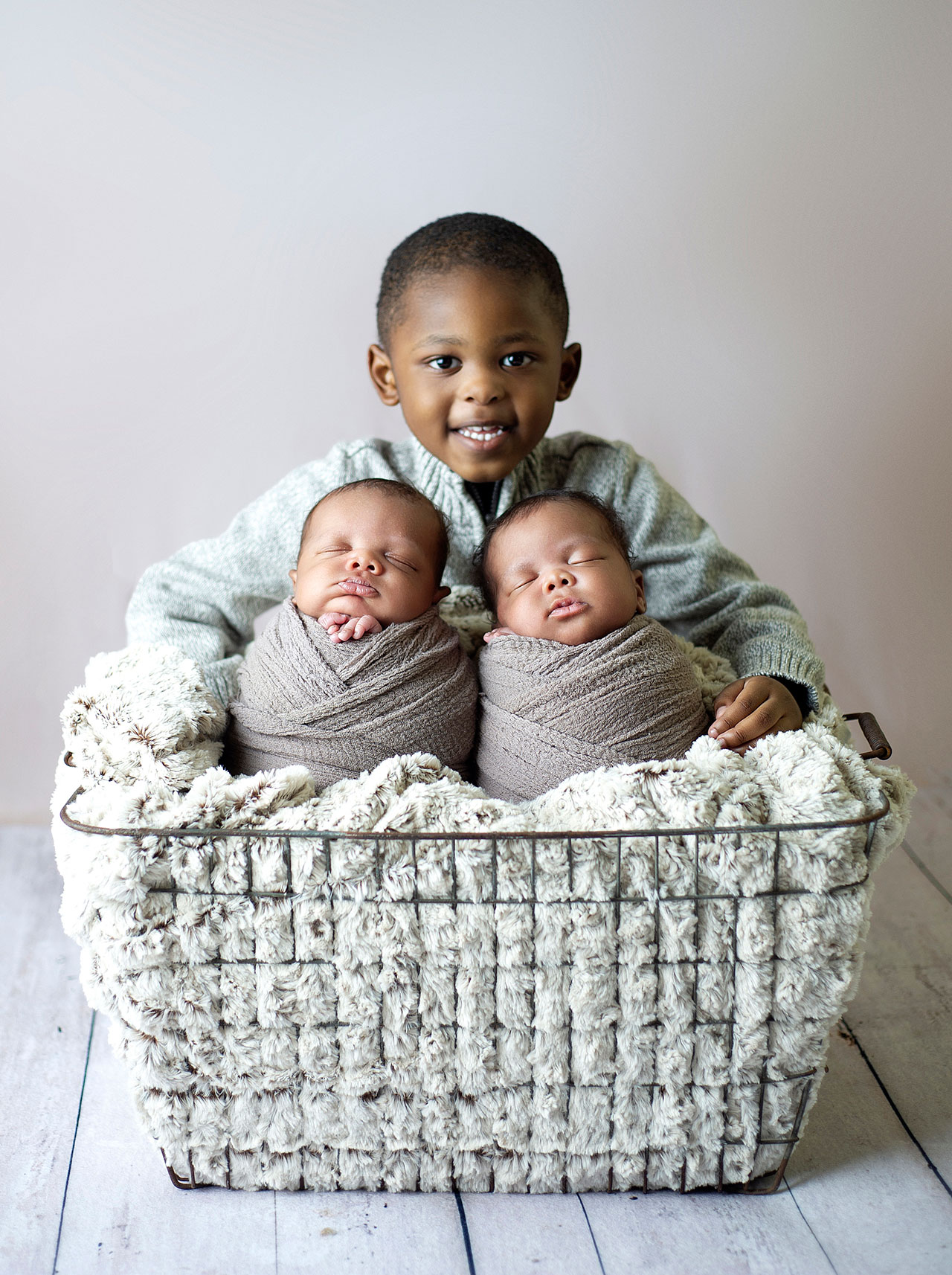 photo of baltimore newborn twins with big brother watching over them in a basket 