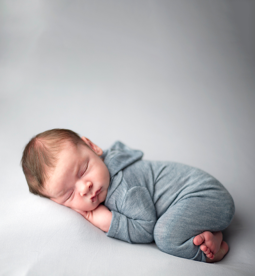 sweet sleeping newborn boy on an all blue background by Maryland Baby Photographer