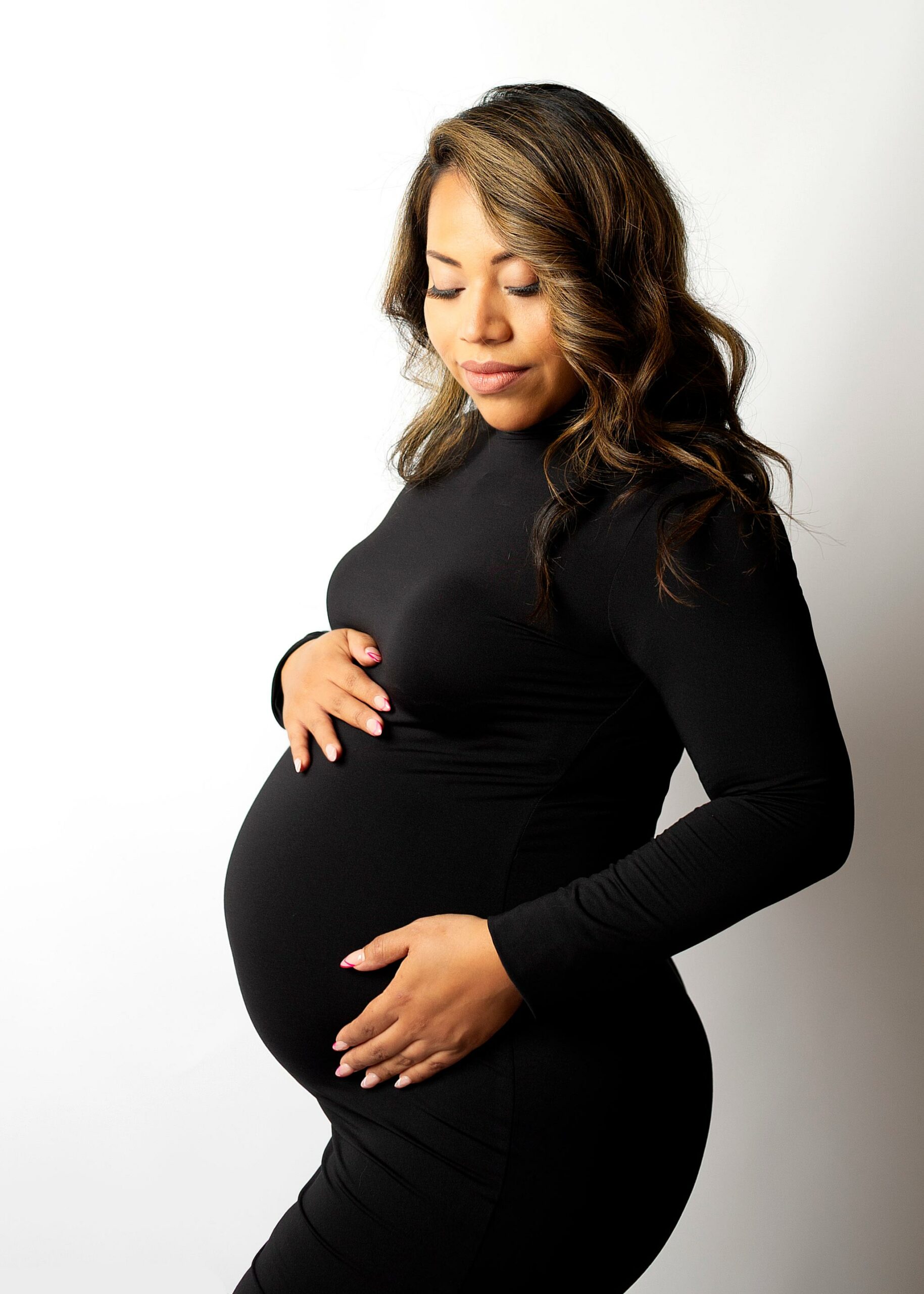 pregnant mom holding her belly wearing a black fitted dress