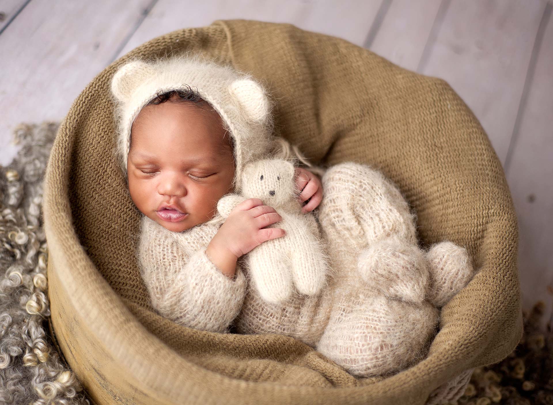 images of a newborn wrapped in a basket holding a teddy bear