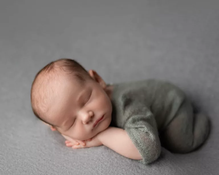picture of a baby sleeping in a must have baby registry gray sleeper